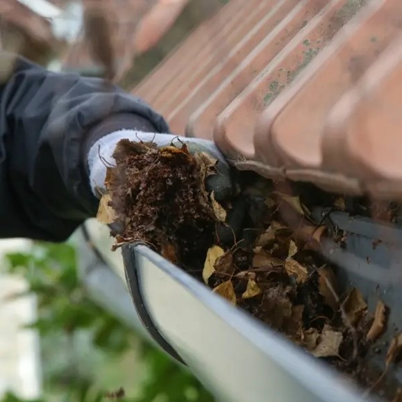 Technician performing rain gutter cleaning service in Salt Lake City, UT